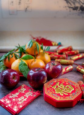 Mandalina ve kırmızı elmalar. Ay Yeni Yıl dekorasyonları ve üzerinde iyi şans, sağlık ve zenginlik sözcükleri olan kırmızı paketler. Bir Çin Yeni Yıl geçmişi, konsept.