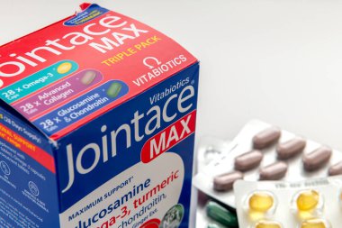 Londra mı? İngiltere-01.01.2025. Osteoartrit tedavisi için bir kutu Jointace sağlık ilavesini kapatın. Dışardaki tabletlerden bazıları beyaz üzerine izole edilmiş..