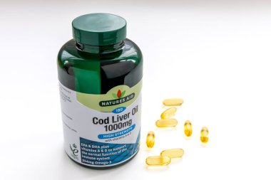 Londra mı? İngiltere-01.01.2025. Morina yağı kapsülleri beyazda izole edilmiş eklem iltihabı için sağlık desteği sağlar..