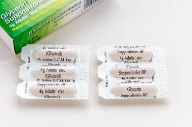 Londra mı? İngiltere-01.01.2025. Şiddetli kabızlık için kullanılan gliserin fitil kapsülleri ve beyaz üzerine izole edilmiş ambalaj kutusu.