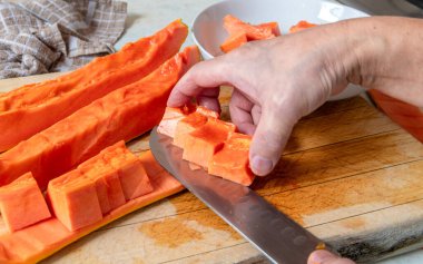 Olgun bir papaya 'yı yemek için hazırlayan kişi derisini yüzmek için bıçak kullanır..