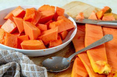 Sarı turuncu, tatlı, yumuşak papaya eti tabaktaki deriden çıkarıldıktan sonra servis edilmeye hazır..