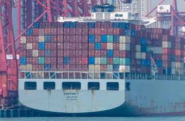 Hong Kong. Çin... 02.18.2025. Hong Kong Limanı rıhtımındaki vinçler tarafından yüklenmiş kargo gemisine yaklaşın..