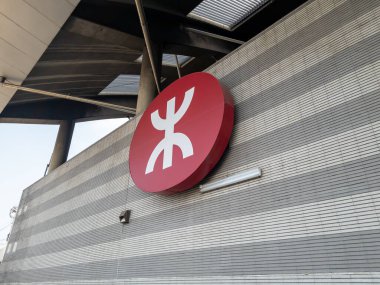 Hong Kong. Çin... 02.18.2025. Logo, sembol, Lai King istasyonunun dış duvarındaki Mass Transit Demiryolu 'nun işareti..