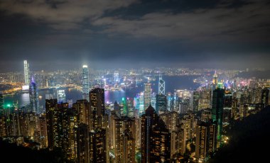Hong Kong. Çin - 02.19.2025. Victoria Peak 'in gece gökdelenleri, Victoria Harbour ve Kowloon yarımadasındaki ikonik gökdelenleri gösteriyor..