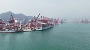 Hong Kong. Çin... 02.18.2025. Hong Kong Limanı 'na yanaşmış bir konteynır gemisinin hava görüntüsü. Rıhtımda yük taşıyan vinçler var..