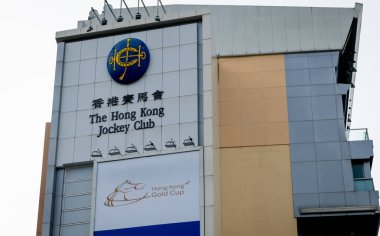 Hong Kong. Çin... 02.21.2025. Hong Kong Jokey Kulübü yarış pistinin ön cephesinde isim işareti ve logosu görülüyor..