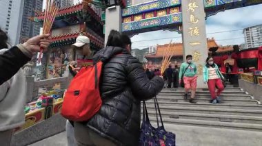 Hong Kong. Çin... 02.24.2025. Ana tapınak kompleksine girmek için ana tapınak kapısından geçen ziyaretçilerin görüntüsü..
