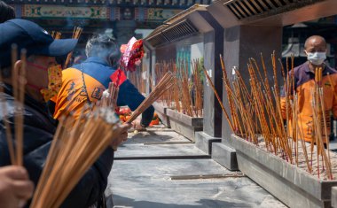 Hong Kong. Çin... 02.24.2025. Shik Sik Yuen Wong Tai Sin Tapınağına gelen ziyaretçiler tütsü ikram edip tanrılara dua ediyorlar..