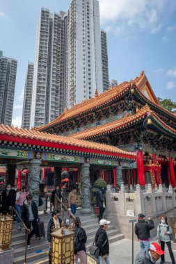 Hong Kong. Çin... 02.24.2025. Shik Sik Yuen Wong Tai Sin Tapınağı 'nın genel iç manzarası modern apartman bloklarının aksine geleneksel Çin mimarisini gösteriyor..