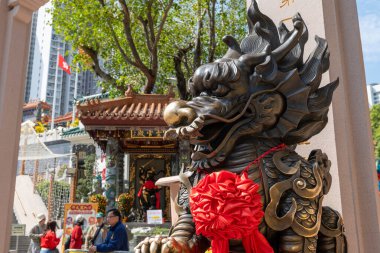 Hong Kong. Çin... 02.24.2025. Shik Shik Yuen Wong Tai Sin Tapınağının girişinde bronz bir ejderha heykeli..