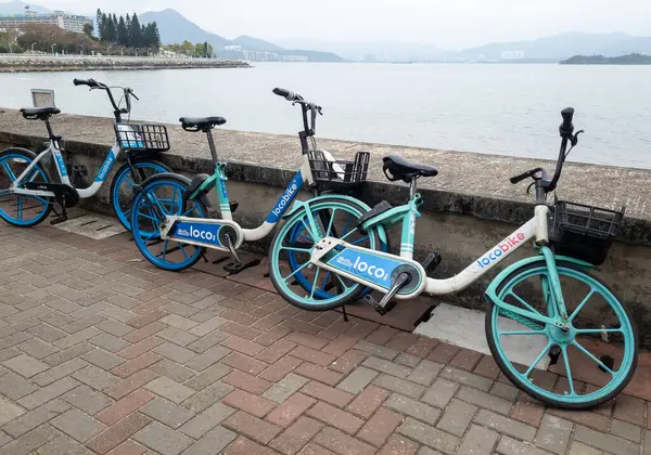 Hong Kong. Çin... 02.22.2025. Motosikletler, Hong Kong 'da Ma On Shan gezinti alanında park edilmiş tek bisiklet paylaşım markası..