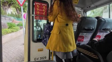 Hong Kong. Çin... 02.26.2025. Bir yolcu taşıyan ve bilet ödeyen bir kamu otobüsünün içinde..