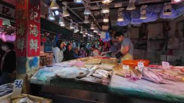 Hong Kong. Çin - 02.25.2025. Tai Po Hui Market, Tai Po ziyaretçileri, bir balıkçıdan taze balık ve deniz ürünleri alıyorlar..