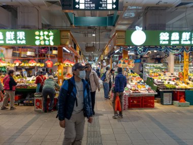 Hong Kong. Çin - 02.25.2025. Tai Po Hui Pazarı 'nın meyve ve sebze bölümünün iç manzarası. Ziyaretçiler taze ürünleri satın alıyor..