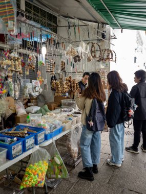 Hong Kong. Çin... 02.26.2025. İnsanlar evcil kuşları için Mong Kok Kuş Pazarı 'ndaki bir perakende mağazasından kuş yemi ve aksesuar alıyorlar..