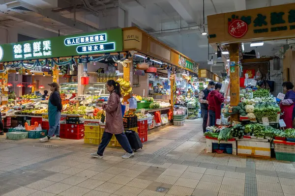 Hong Kong. Çin - 02.25.2025. Tai Po Hui Pazarı 'nın meyve ve sebze bölümünün iç manzarası. Ziyaretçiler taze ürünleri satın alıyor..