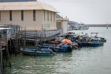 Hong Kong. Çin... 02.27.2025. Deniz kanalının girişiyle Lantau Adası 'ndaki Tai O balıkçı köyünün limanı arasına demirlemiş küçük tekneler..