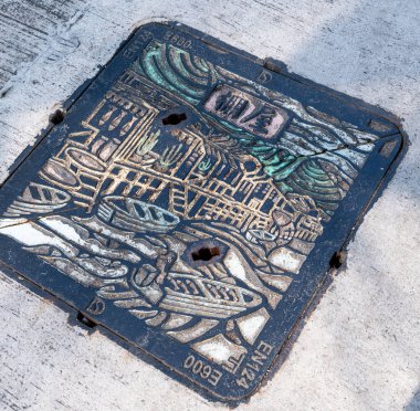 Hong Kong. Çin... 02.27.2025. Tai O köyünde bir lağım kapağı. Metalden yapılmış. Balıkçı köyünün sanat tasarımı..