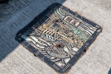 Hong Kong. Çin... 02.27.2025. Tai O köyünde bir lağım kapağı. Metalden yapılmış. Balıkçı köyünün sanat tasarımı..