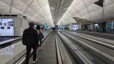 Hong Kong. Çin... 03.05.2025. Hong Kong Uluslararası Havaalanı Terminali 1 'deki yolcu uçağına yetişmek için kalkış kapılarına gidiyor..