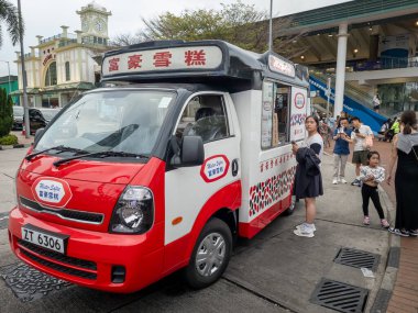 Hong Kong. Çin - 03.03.2025. Hong Kong Gözlem Çarkı 'nın yanında müşteri kuyruğu olan bir dondurma kamyonu..