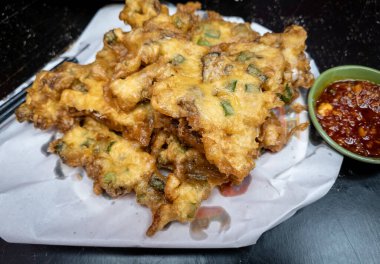 Kızarmış istiridye ve yumurta yanında da acı biber sosu..