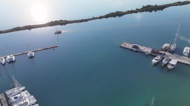 Güneşli, sakin bir sabahta yat limanına doğru yelken açan bir yat. Havadan üst görünüm.