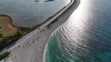 Öğleden sonra, deniz ve tuz bataklıkları arasındaki doğal bir geçitin hava klipsi güzel güneş ışığı yansımalarıyla eğildi..