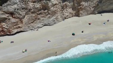 Porto Katsiki Sahili 'nin yükselen hava manzarası. Güzel dalgalar, mavi deniz ve tatilin tadını çıkaran turistler. Lefkada Adası, Yunanistan.