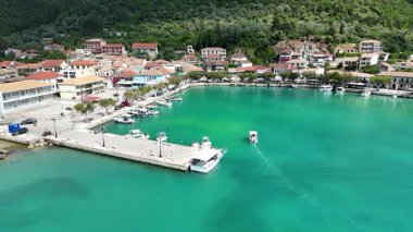Turistler arasında popüler bir Yunan adası köyünün limanına giren küçük bir tekne. Hava görüntüleri.