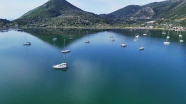Geni Körfezi 'nin üzerinde sakin sulara demirlemiş yelkenli teknelerle uçan bir hava aracı. Lefkada Adası, Yunanistan.