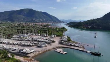 Doğal deniz kanalı körfezi, deniz körfezi, gemi tersanesi ve sakin sularda yüzen tekneleri olan bir Yunan adasının hava manzarası..