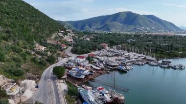 Küçük bir Yunan ada tersanesinin üzerinde uçan yelkenli yatlar ve küçük gemiler..