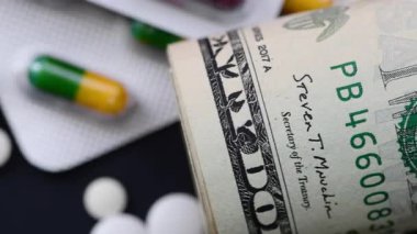 Macro siyah üzerine izole edilmiş bir rulo Amerikan doları, bayrağı ve ilacını kapat. Tıbbi maliyet konsepti.