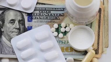 ABD Doları banknotları ile tıp konsepti üzerine bir gümrük vergisi ve çeşitli tıbbi haplarla çevrili Gümrük tarifesi..