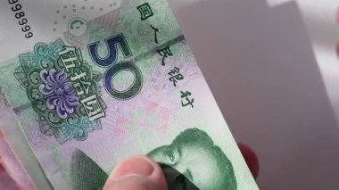 50 ve 100 Yuan 'lık Çin banknotları sayan birinin yakın çekim videosu..