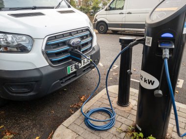 London. UK- September 12. 2025. A full electric Ford van using a roadside charging point to charge its batteries.