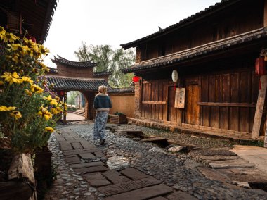 Antik Dali şehrinin küçük sokaklarını geleneksel binalarla keşfeden bir kadın. 