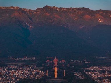Old Town of Dali with Three Pagodas during the sunset time. Chongsheng Temple and Cangshan Mountains