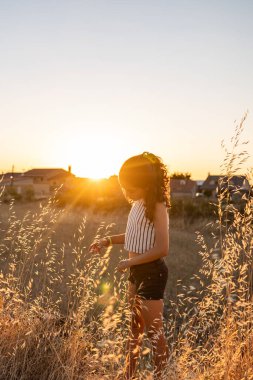 Teen girl exploring a straw field in the countryside