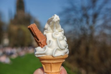 Edinburgh, Birleşik Krallık 'taki Princes Street Garden' ın bulanık arka planına sahip çikolatalı dondurma külahı..