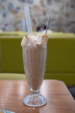 Çikolatalı milkshake. Masada yanmış marshmallow ve bulanık bir arka planı var.