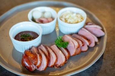 Kızarmış ördek göğsü, tabakta sos ile servis edilir.