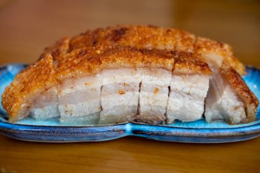 Kızarmış domuz eti tabakta servis edilir, yemeye hazır.