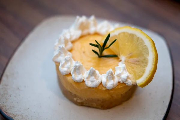 Lemon tart with cream and lemon served on plate