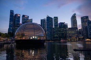 Singapur - 20 Ekim 2022: Apple Marina Bay Sands ve günbatımı gökyüzü. Foster + Partners tarafından tasarlanan Dünyanın İlk Yüzen Elma Mağazası.