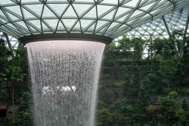 Singapur - 22 Ekim 2022: Jewel Changi Havaalanı 'ndaki dünyanın en uzun kapalı şelalesi. Changi Havalimanı ile çevrili doğa temalı bir eğlence ve perakende tesisidir.