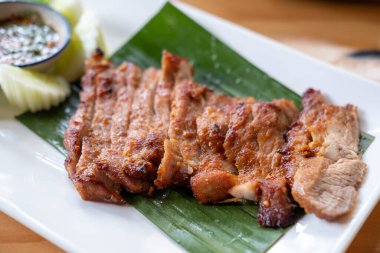 Ahşap tabakta servis edilen ızgara domuz boynu.