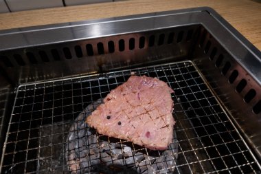 Paslanmaz ızgarada Kore usulü barbekü. Yumuşak odaklı az pişmiş et.